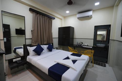 a bedroom with two beds and a sink and a mirror at Hotel Triton - Near US Embassy in Mumbai