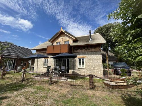 ein Haus mit einem Zaun davor in der Unterkunft Boddenkutter in Born