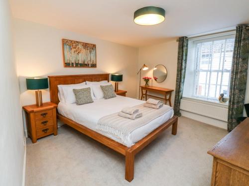 a bedroom with a bed and two lamps and a window at Pilchard Cottage in Dawlish