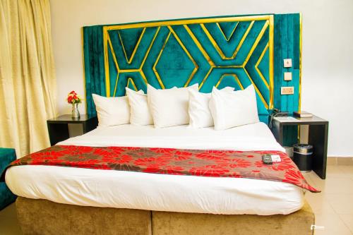 a bedroom with a large bed with a colorful headboard at Suru Express Hotel in Suru Lere