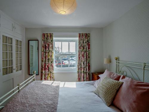 a bedroom with a large bed and a window at 4 Bed in Bude CRESC in Bude