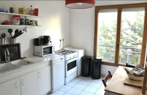 a kitchen with a white stove top oven next to a window at Le Vendôme - Shared Appartment in Lyon