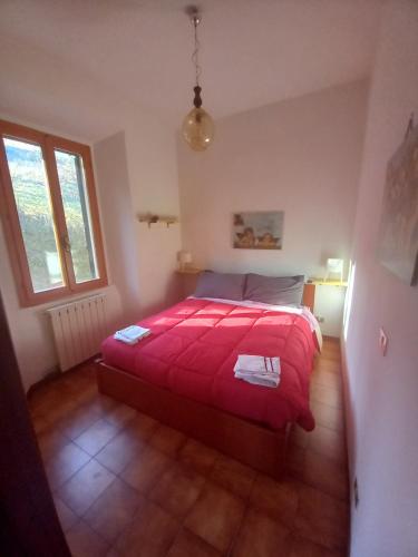 ein Schlafzimmer mit einem großen roten Bett in einem Zimmer in der Unterkunft residence La Bolognina 2 in Lizzano in Belvedere
