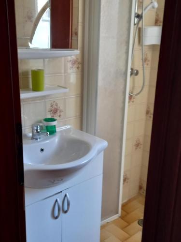 La salle de bains est pourvue d'un lavabo blanc et d'une douche. dans l'établissement residence La Bolognina 2, à Lizzano in Belvedere