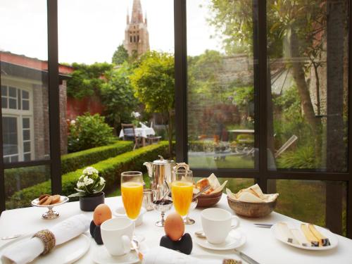 una mesa con huevos y vasos de zumo de naranja en B&B Alphabet - Luxury Guesthouse and Art Gallery, en Brujas