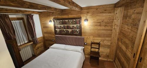 ein kleines Zimmer mit einem Bett und einem Stuhl in der Unterkunft COURMAYEUR, VERRAND: IMMERSA NEL VERDE E CON VISTA in Verrand