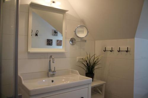 a bathroom with a sink and a mirror at Ferienwohnung Abendsonne in Born