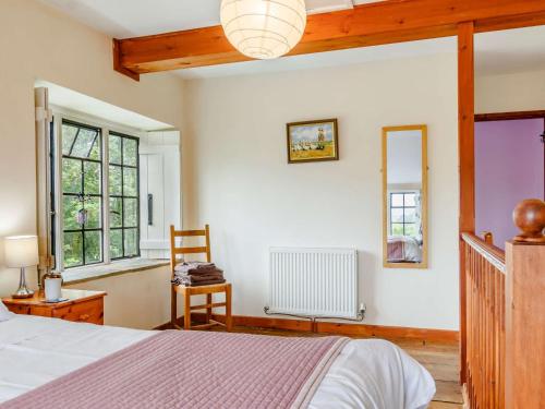 um quarto com uma cama, uma cadeira e janelas em 1 Bed in Yeovil HYDEC em West Coker