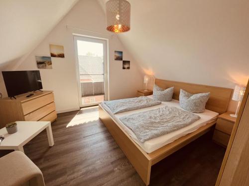 a bedroom with a bed and a tv in it at Ferienhaus Niege Schüün in Born