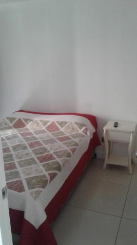 Bett mit einer roten und weißen Bettdecke in einem Zimmer in der Unterkunft DESCANSO DEL VIAJERO 2 in Santiago