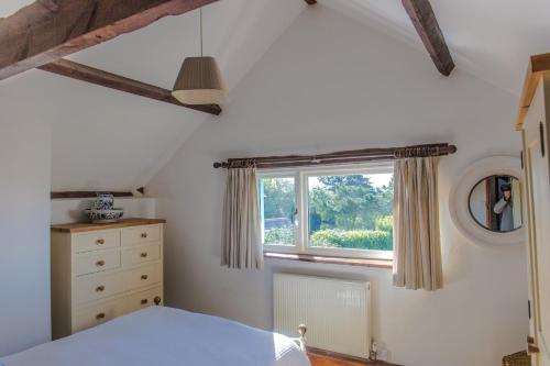 a bedroom with a window and a dresser at The Granary in Hartland