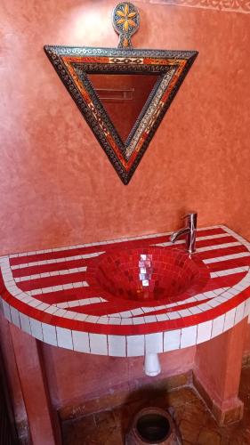a bathroom with a red sink and a mirror at Les Bains de Fez Tara in Fès