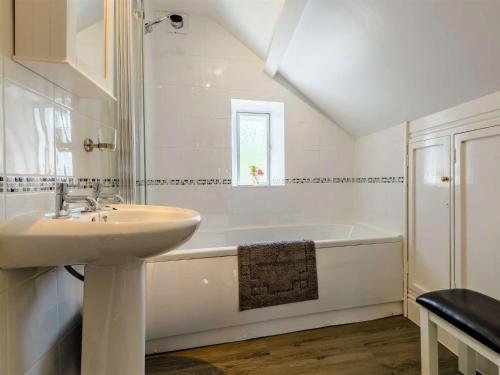 a white bathroom with a sink and a bath tub at 3 Bed in Pooley Bridge 89068 in Tirril