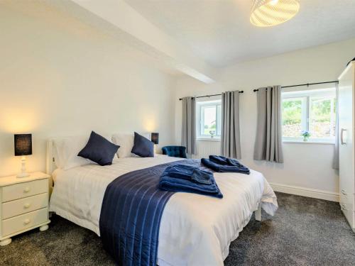 a bedroom with two beds and two windows at 3 Bed in Pooley Bridge 89068 in Tirril