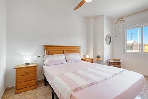 ein Schlafzimmer mit einem großen Bett und einem Fenster in der Unterkunft Playa de Chilches in Chilches
