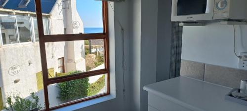 a kitchen with a window with a view of the ocean at Paters Haven Self-catering and B&B in Paternoster