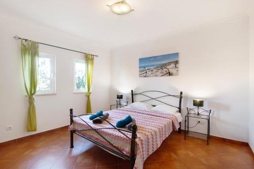 een slaapkamer met een bed en 2 ramen bij Casa Palma in Paderne