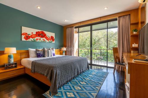 um quarto com uma cama e uma grande janela em The Unity and The Bliss Patong Residence em Praia de Patong