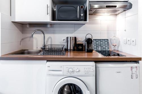 a kitchen with a washing machine and a sink at Charmant et fonctionnel in Talence