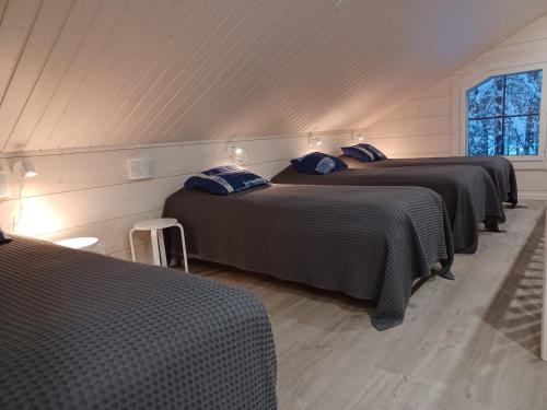 una fila de tres camas en una habitación en Levi President Suksitie Chalet, en Levi
