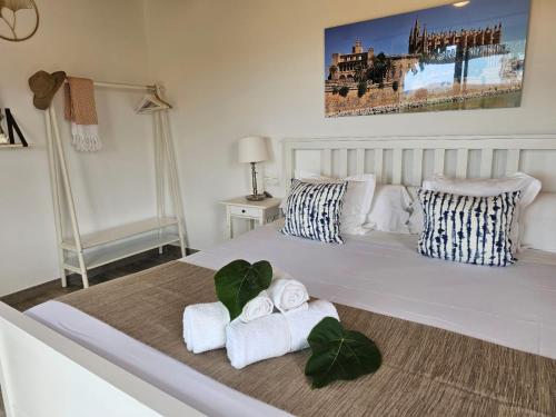 a bedroom with a large white bed with towels on it at Agroturisme Es Racó De Maria in Maria de la Salut