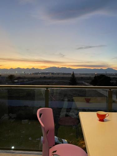 einen Tisch und einen Stuhl auf einem Balkon mit Blick auf den Sonnenuntergang in der Unterkunft Alp in Aksu