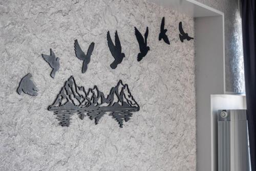 a wall with a painting of birds and mountains at Gudauri premium apartments in Gudauri