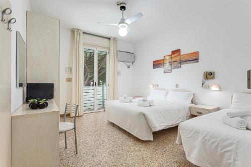 a hotel room with two beds and a television at Hotel Cuba in Milano Marittima