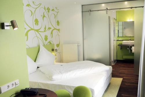 ein Schlafzimmer mit einem weißen Bett und einem Gemälde an der Wand in der Unterkunft Gasthaus Rössle in Kirchheim unter Teck