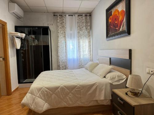 a bedroom with a white bed and a window at Hostal El Brillante - Alojamientos El Duque in Córdoba