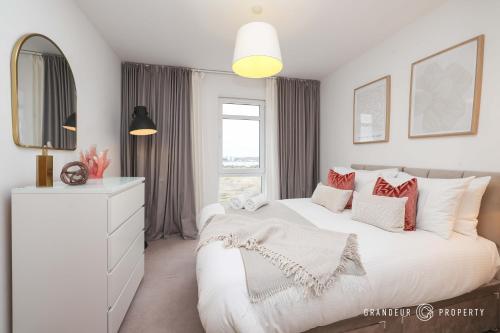 a white bedroom with a large bed and a mirror at Poole Quay, elegant apt, sleeps 4, Wi-Fi & parking - Carters Quay View in Poole