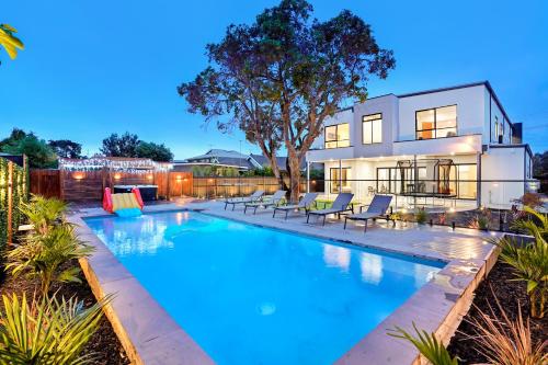 a swimming pool in front of a house at Amazing Backyard - MAX Entertain Beachside Retreat in Tootgarook