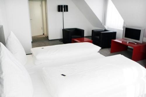 1 Schlafzimmer mit einem weißen Bett und einem TV in der Unterkunft Gasthaus Rössle in Kirchheim unter Teck