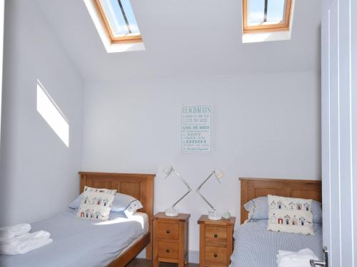 two beds sitting next to each other in a bedroom at 2 Bed in Winterton-on-Sea LOWFA in Winterton-on-Sea