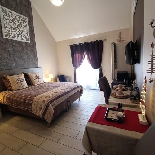 a bedroom with a bed and a table and a window at Le balcon des cimes in Adast