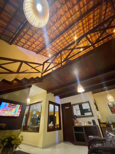 a living room with a ceiling with a light at Pousada Yapara-Tyba in Japaratinga
