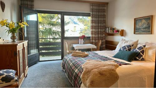 ein Schlafzimmer mit einem großen Bett und einem Fenster in der Unterkunft Apartment A'Horn in Sankt Johann in Tirol