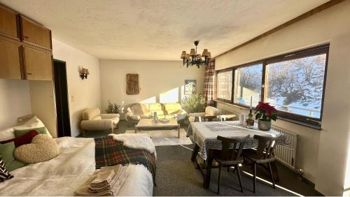 ein Wohnzimmer mit einem Bett, einem Tisch und Stühlen in der Unterkunft Apartment A'Horn in Sankt Johann in Tirol