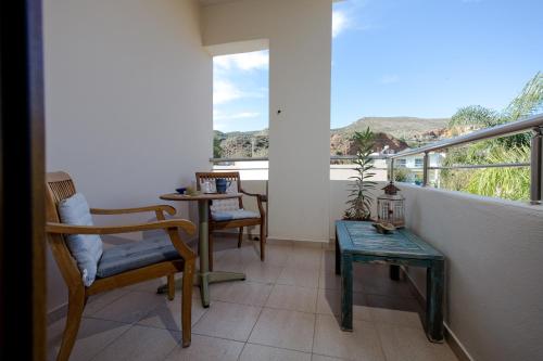 a balcony with chairs and a table and a window at Arodamos Studios & Apts in Kissamos