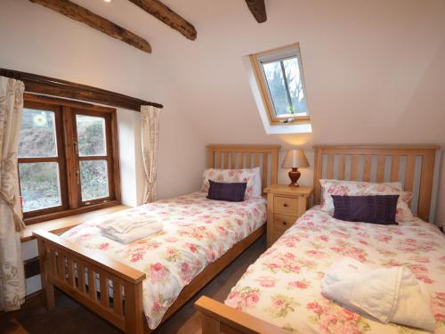 2 Betten in einem Schlafzimmer mit 2 Fenstern in der Unterkunft 4 Bed in Bewdley OSHIP in Highley