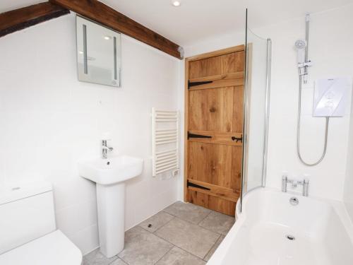 a white bathroom with a sink and a shower at 4 Bed in Berrynarbor 43640 in Berrynarbor