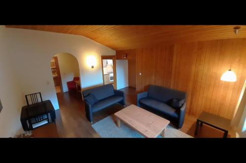 una sala de estar con 2 sofás azules y una mesa. en Ferienwohnung Tschagguns Top 5, en Schruns
