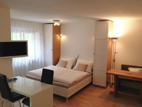 a bedroom with a bed and a table and a desk at Ferienwohnung Tschagguns in Schruns-Tschagguns