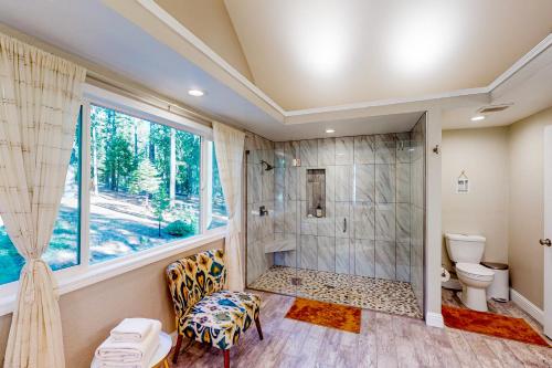 ein Bad mit einer Dusche, einem WC und einem Fenster in der Unterkunft Peaceful Pines in Nevada City