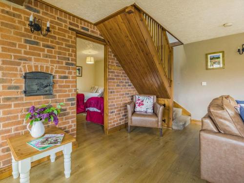 a living room with a brick wall and a staircase at 3 bed in Worcester CC030 in Clifton upon Teme
