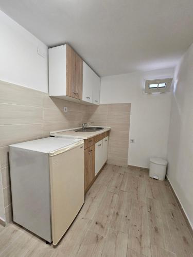 an empty kitchen with a sink and a refrigerator at Apartmani Radman 2 - Igalo in Igalo
