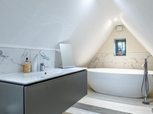 La salle de bains est pourvue d'une baignoire blanche et d'un lavabo blanc. dans l'établissement 3 bed in Stow-on-the-Wold 49965, à Lower Swell