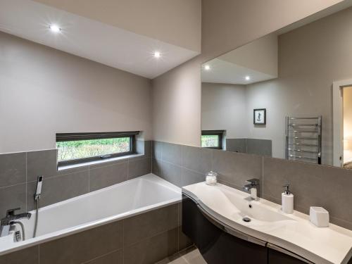 uma casa de banho com uma banheira, um lavatório e um espelho. em 2 Bed in Eye 51468 em Wortham