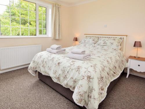 a bedroom with a large bed with towels on it at 2 Bed in Padstow 51925 in Egloshayle