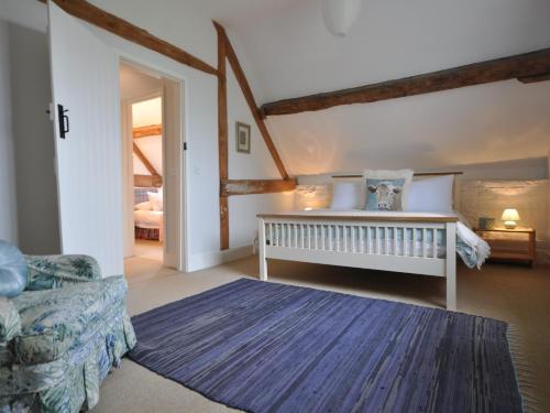 a bedroom with a bed and a couch in a room at 3 Bed in Stratford-upon-Avon 54081 in Ettington